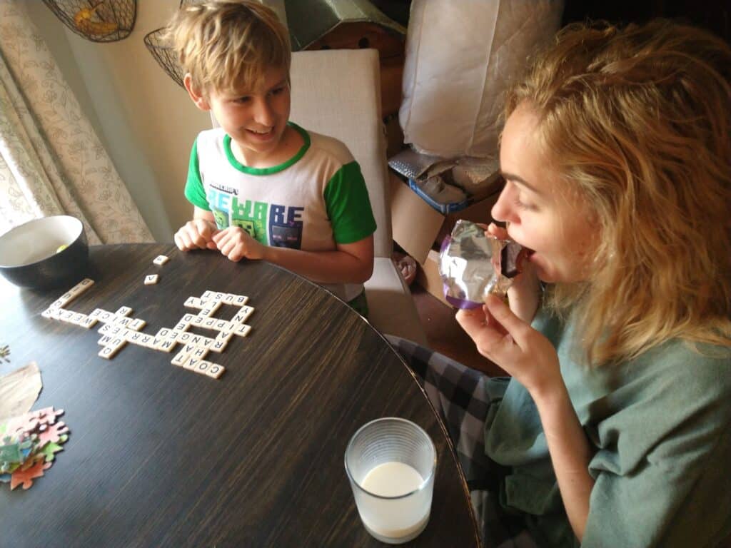 A brother and sister playing a game at a table.