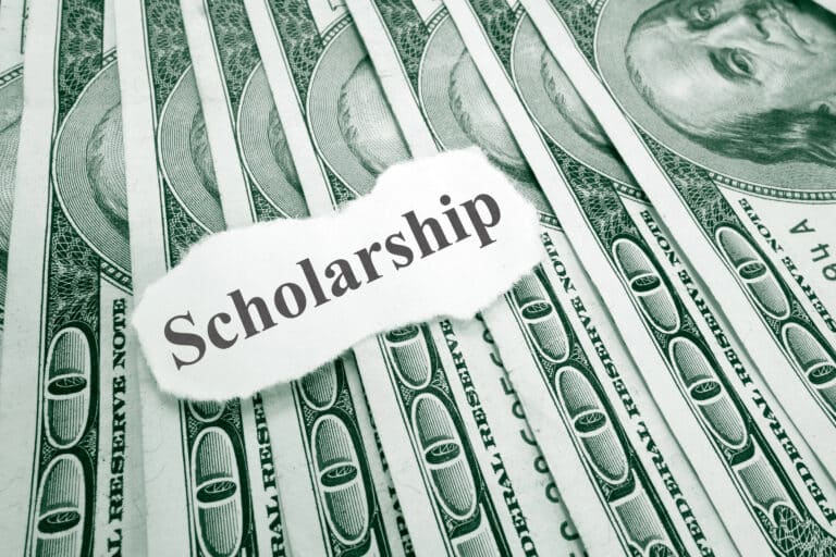 scholarship written on a slip of paper on top of dollar bills