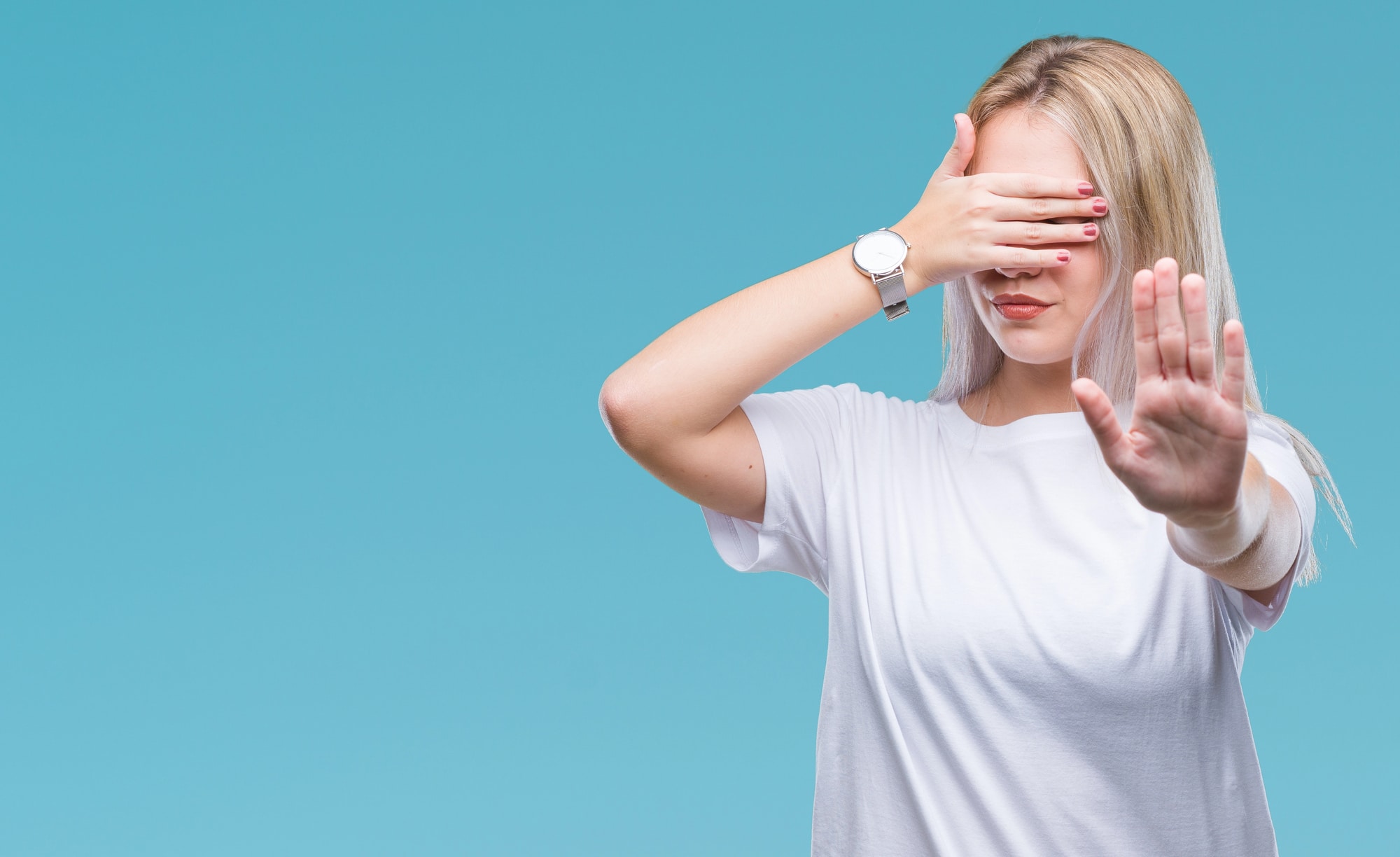 woman covering her eyes and putting up a hand to say stop to decrease stress